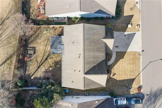 an aerial view of a house with a yard and a large tree