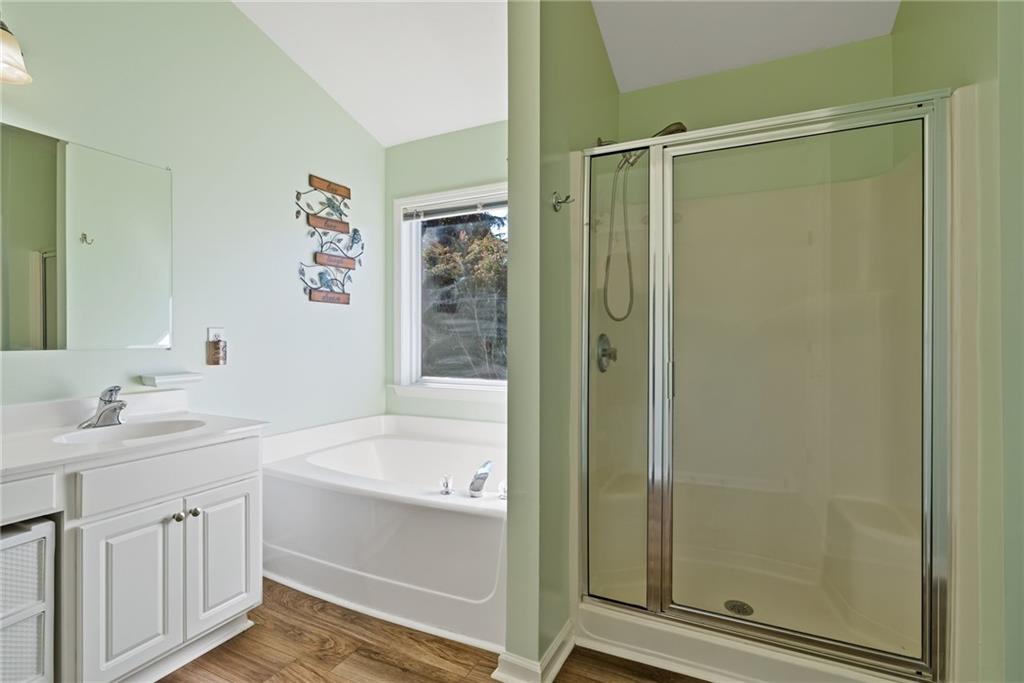 232 Springs Crossing Canton, GA 30114 - Photo 40 of 57 a bathroom with a bathtub a shower a sink and a mirror