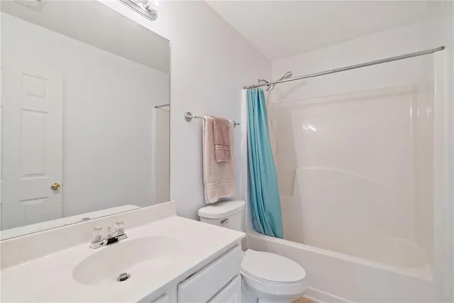 an empty room with a chandelier fan and windows