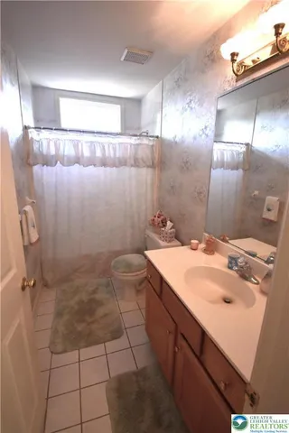 a spacious bathroom with a tub sink and a mirror