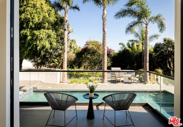 a view of a patio with couches table and chairs and potted plants