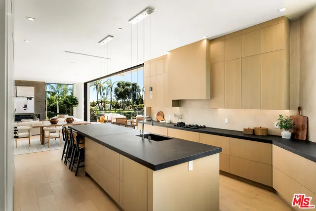 a kitchen with stainless steel appliances a stove sink and white cabinets with wooden floor