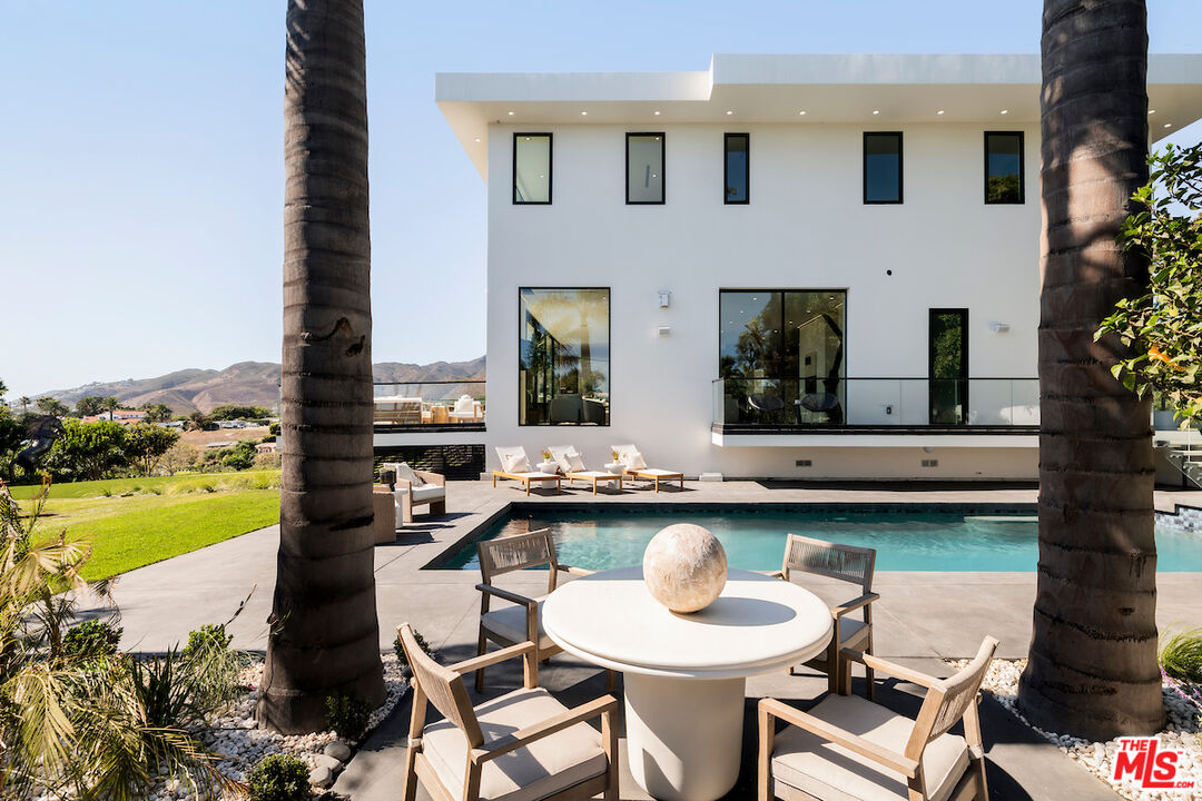 5931 Kanan Dume Road Malibu, CA 90265 - Photo 41 of 50 a view of a patio with dining table and chairs with wooden floor