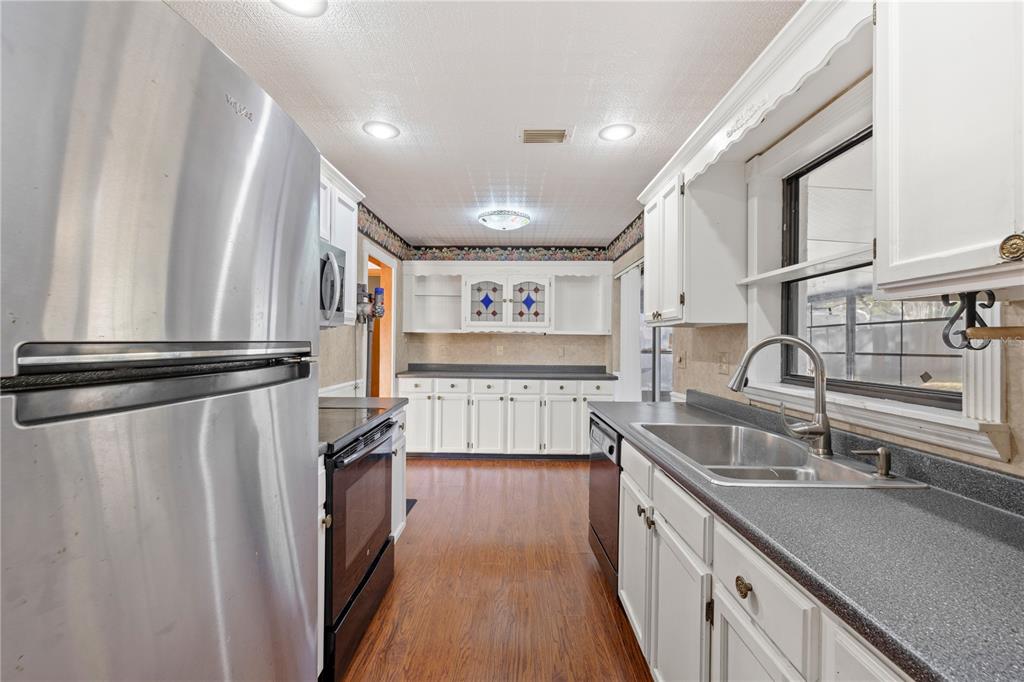 5444 Lighthouse Road Orlando, FL 32808 - Photo 16 of 36 a kitchen with stainless steel appliances granite countertop a refrigerator and a sink