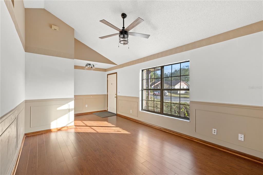 5444 Lighthouse Road Orlando, FL 32808 - Photo 6 of 36 a view of an empty room with a window and wooden floor