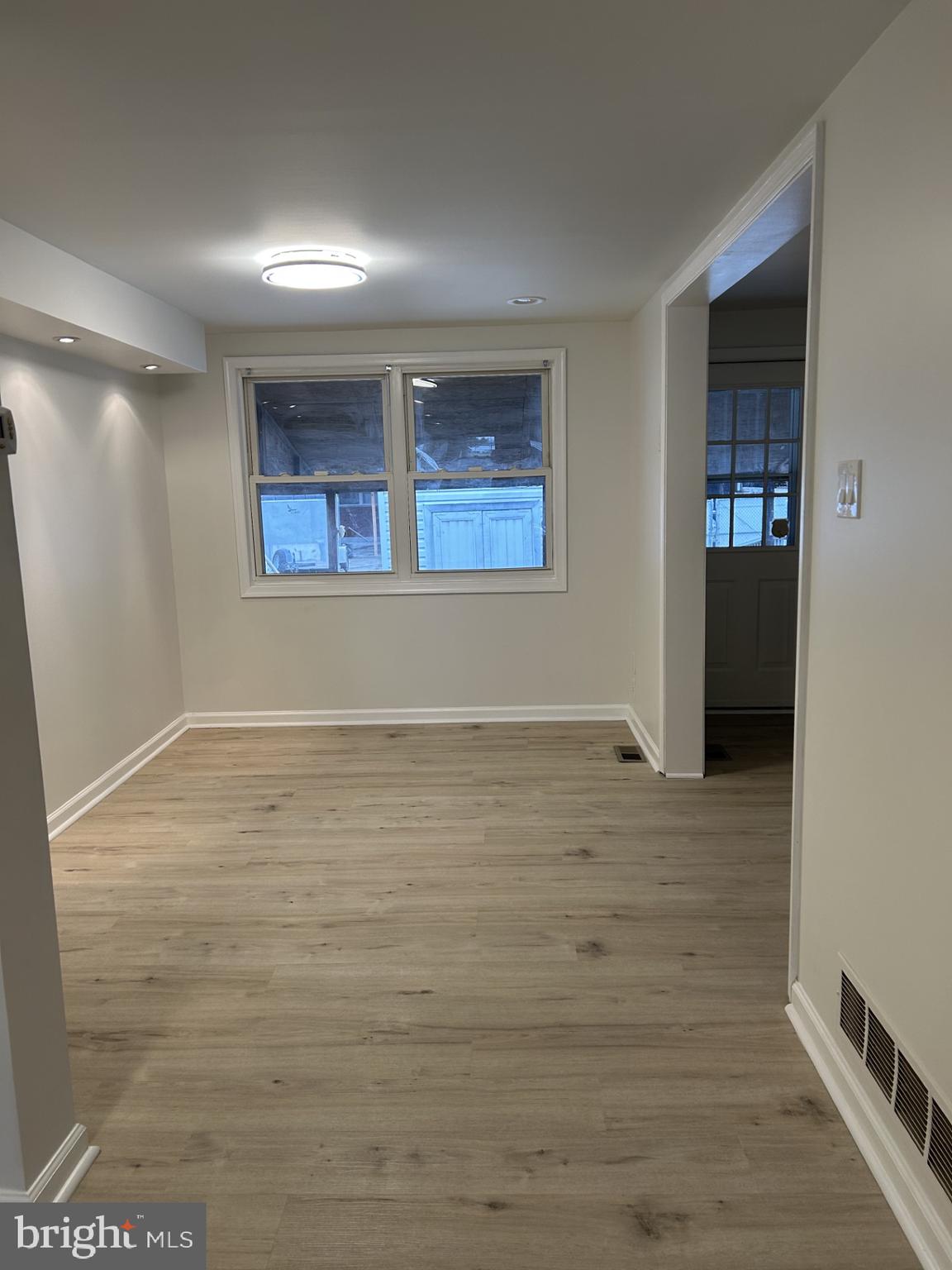 4024 St Augustine Lane Dundalk, MD 21222 - Photo 4 of 17 a view of an empty room with wooden floor and a window