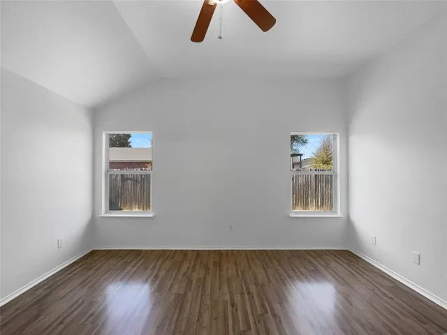 an empty room with wooden floor closet and window