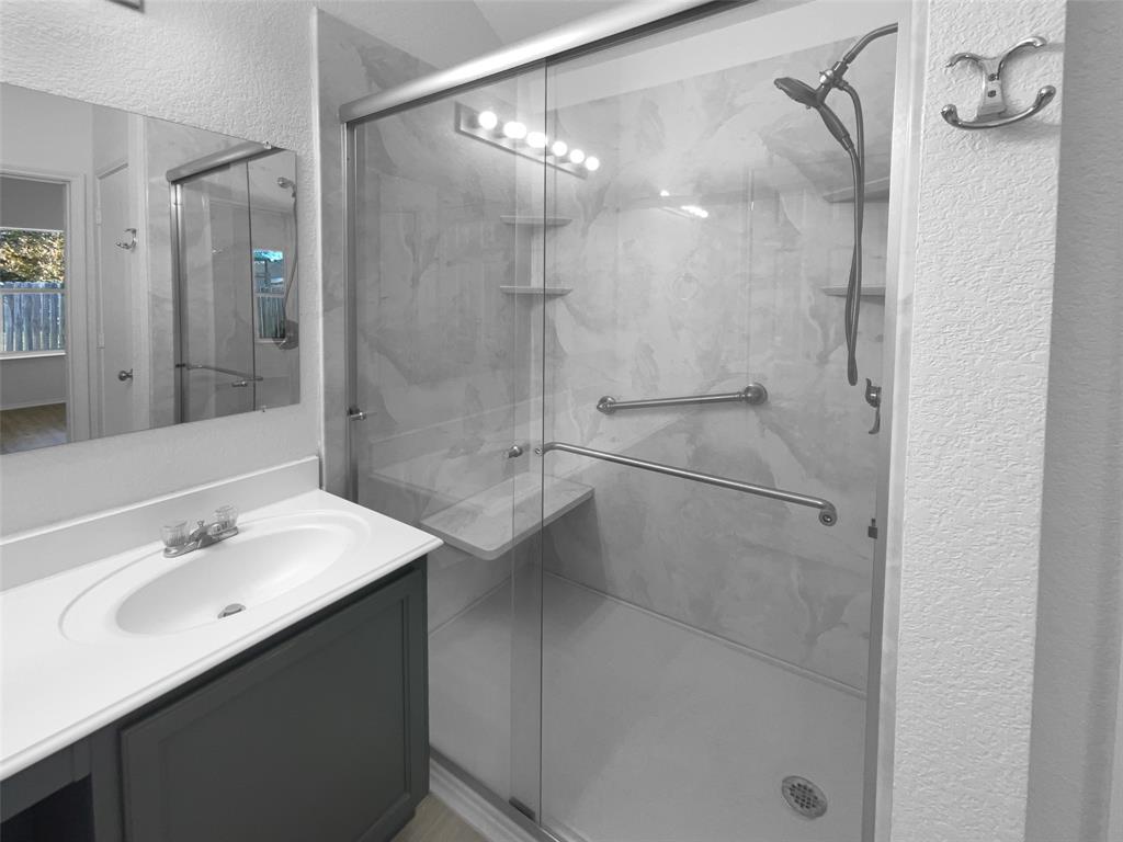 104 Crown Drive Rhome, TX 76078 - Photo 18 of 20 a bathroom with a shower sink vanity and mirror