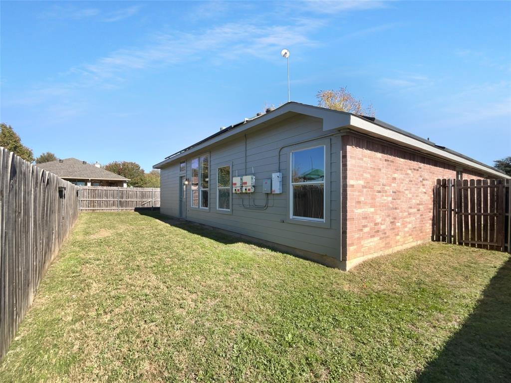104 Crown Drive Rhome, TX 76078 - Photo 19 of 20 a yellow house with yard in front of it