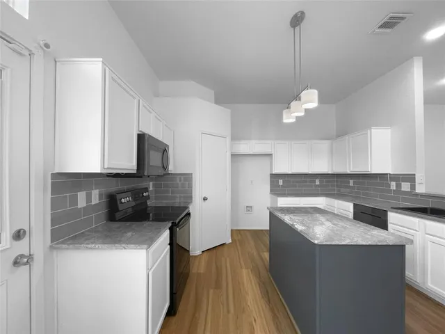 a kitchen with stainless steel appliances granite countertop a sink a stove and a refrigerator