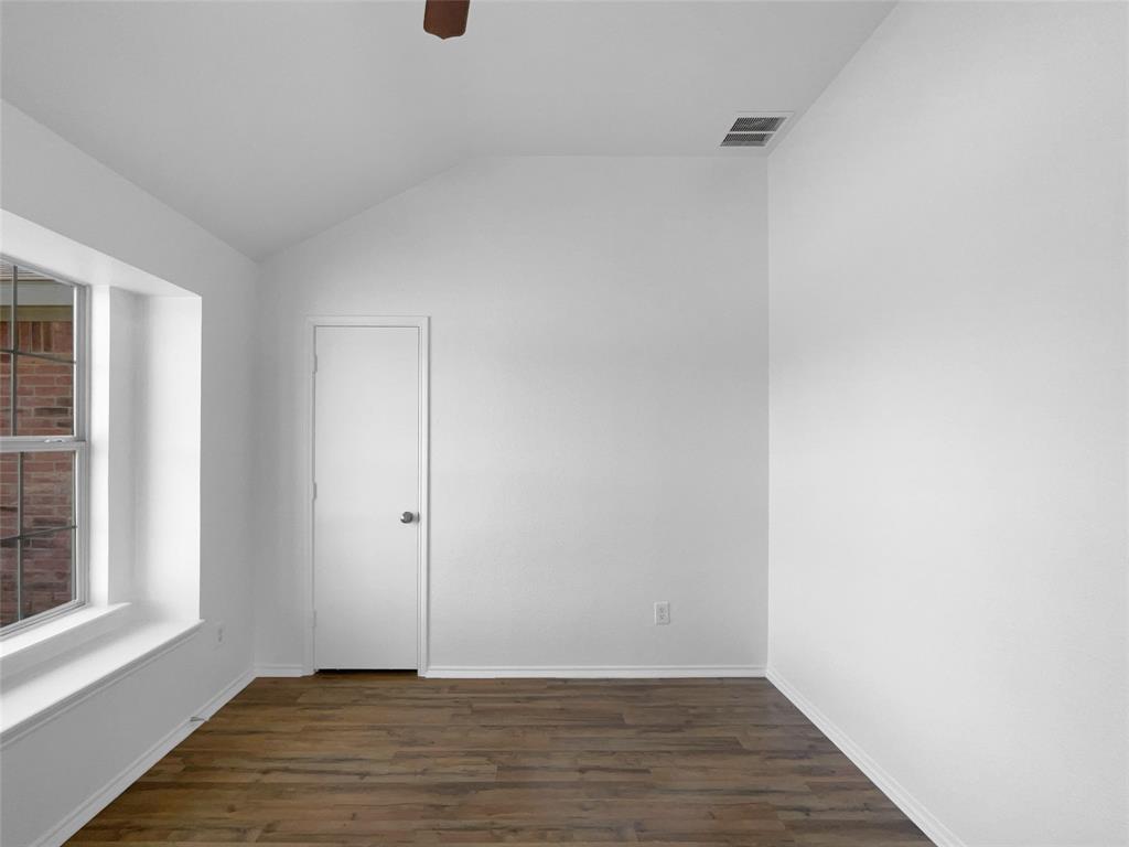 104 Crown Drive Rhome, TX 76078 - Photo 8 of 20 a view of an empty room with wooden floor and a window