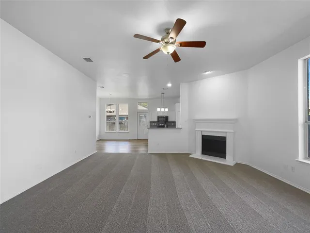 a view of an empty room with a fireplace and a window