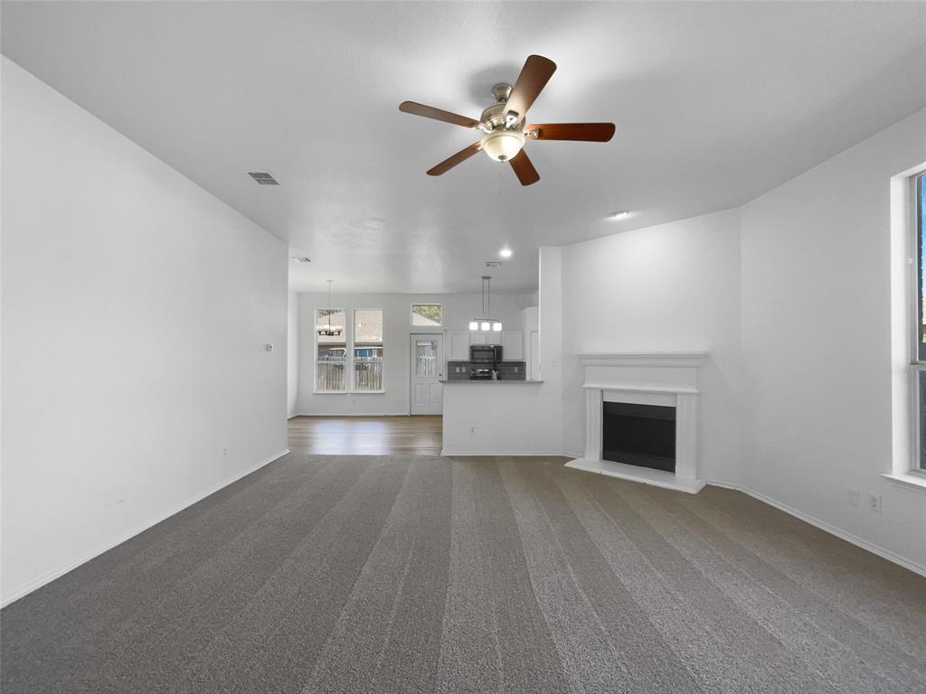 104 Crown Drive Rhome, TX 76078 - Photo 10 of 20 a view of an empty room with a fireplace and a window