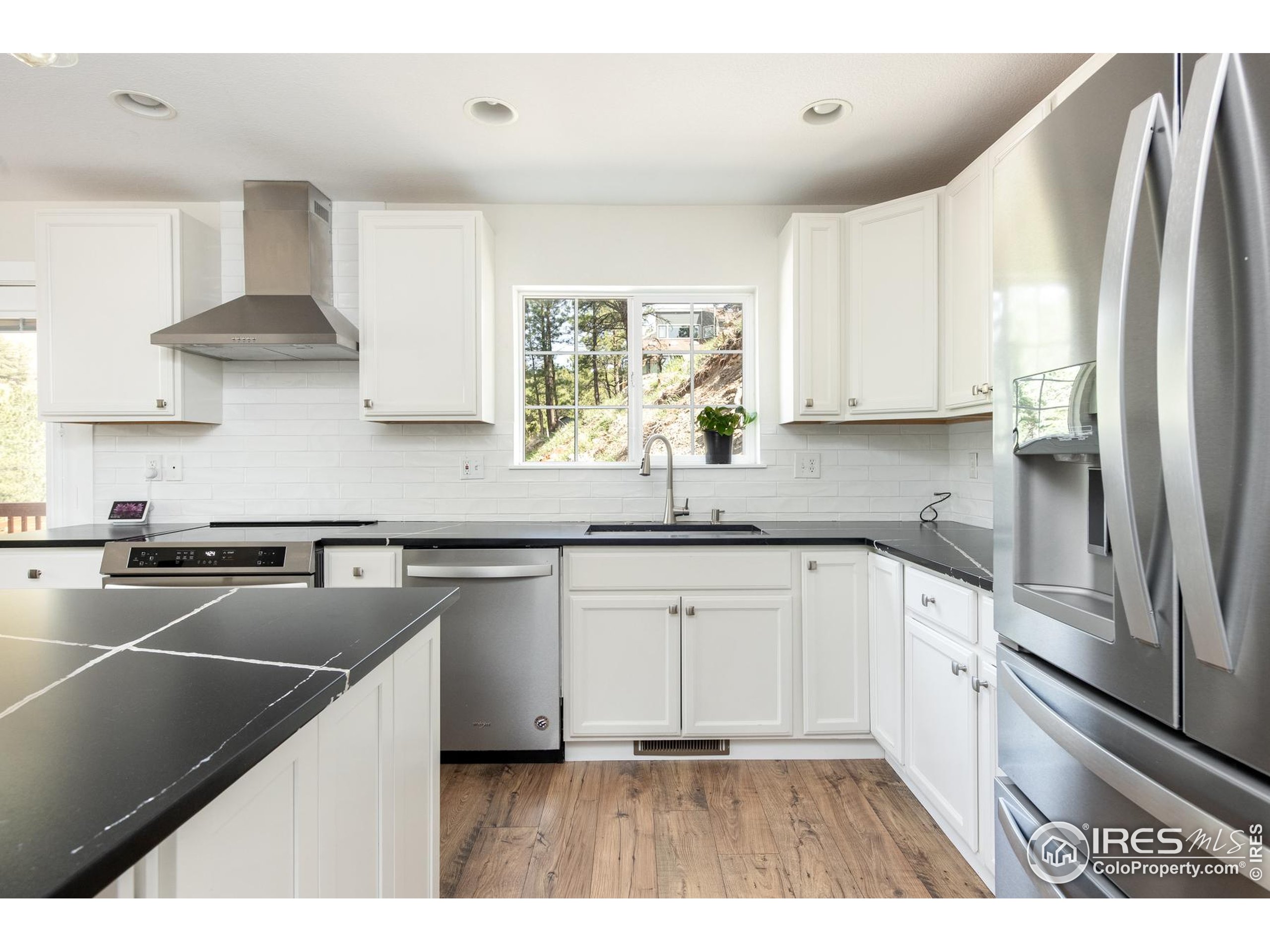 93 Pine Needle Road Boulder, CO 80304 - Photo 31 of 48 a kitchen with stainless steel appliances white cabinets a sink a stove a refrigerator and island