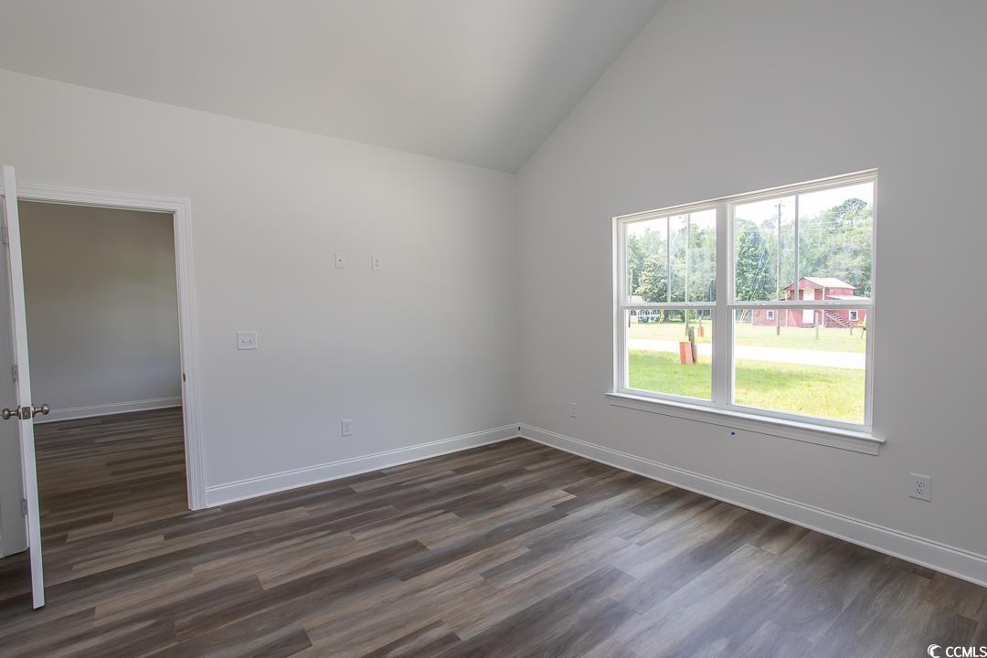 3858 Red Bluff Road Loris, SC 29569 - Photo 15 of 29 Empty room with high vaulted ceiling and dark wood