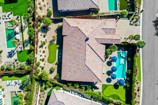 a view of a swimming pool with lawn chairs under an umbrella