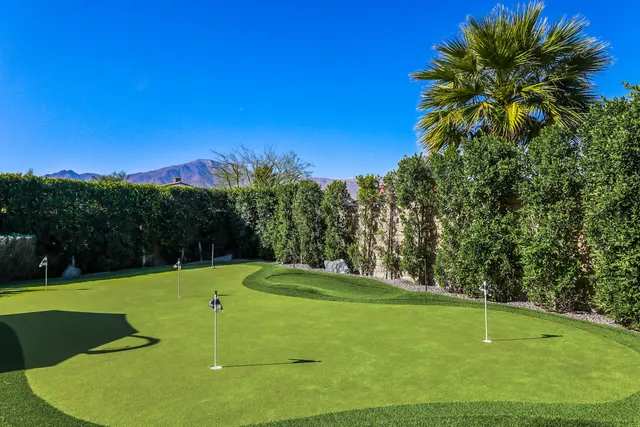 a view of the patio with dining table and chairs under an umbrella