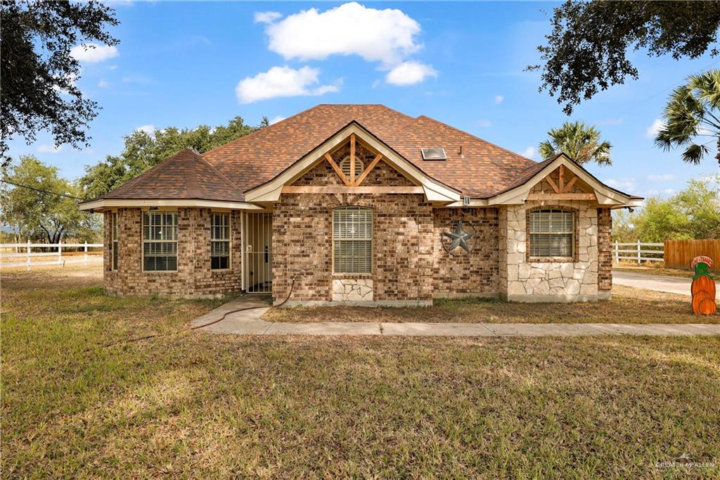 1401 East Mile 3 Road Palmhurst, TX 78573 - Photo 1 of 16 a front view of a house with a garden