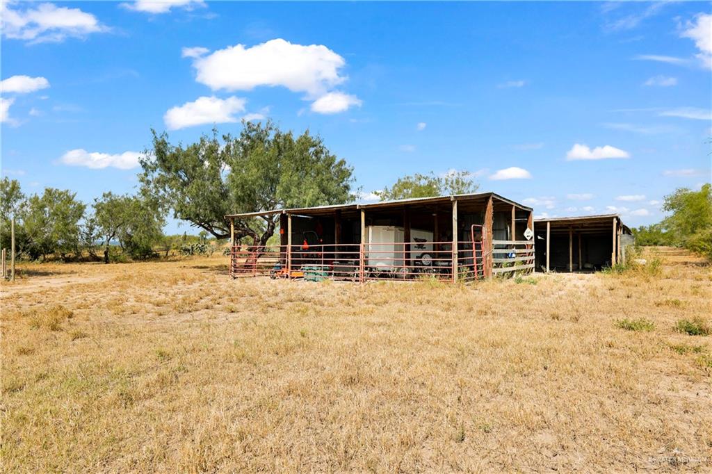 1401 East Mile 3 Road Palmhurst, TX 78573 - Photo 7 of 16 a backyard of a house with table and chairs under an umbrella