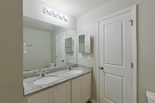 a bathroom with a granite countertop sink and a mirror