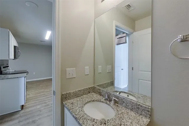 a bathroom with a granite countertop sink a mirror and a shower