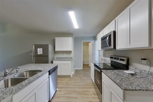 a kitchen with stainless steel appliances granite countertop a sink stove and cabinets