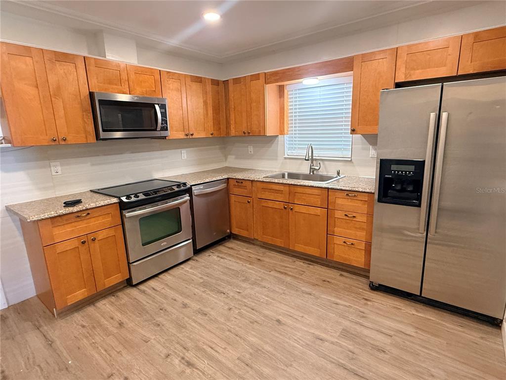 1908 West St Louis Street Tampa, FL 33607 - Photo 2 of 28 a kitchen with stainless steel appliances granite countertop a stove microwave and sink