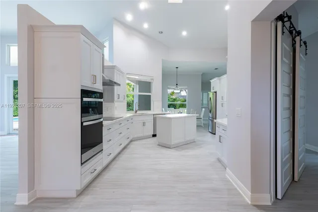 a kitchen with stainless steel appliances a refrigerator and a cabinets