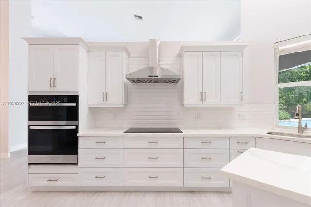 a kitchen with white cabinets and appliances