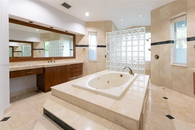 a spacious bathroom with a bathtub sink and mirror