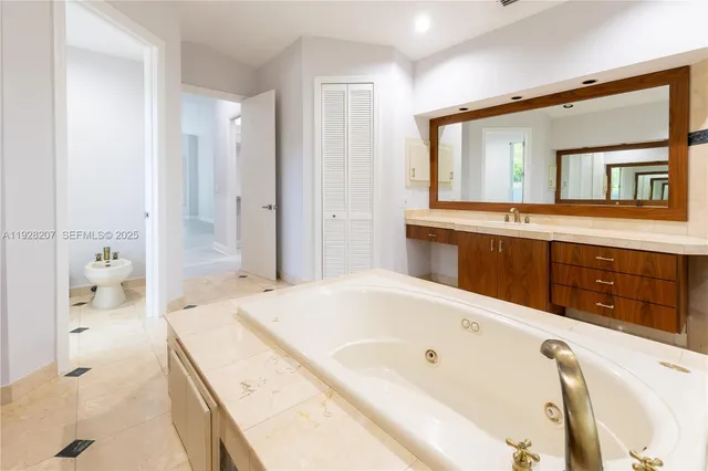 a spacious bathroom with a tub sink and mirror