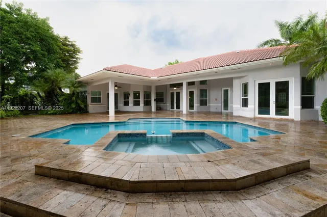 a view of house with yard and swimming pool