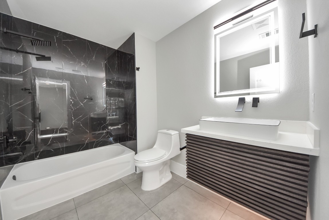 602 West 28th Street, Unit A Houston, TX 77008 - Photo 32 of 41 a bathroom with a sink a toilet a mirror and bathtub