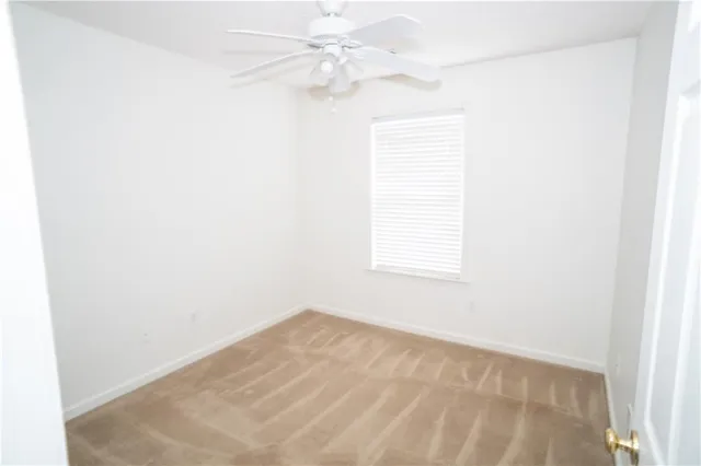 a view of a room with a window and a ceiling fan