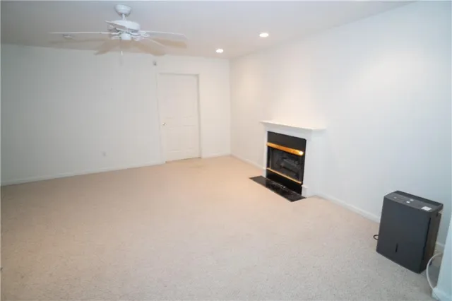 an empty room with windows and fireplace