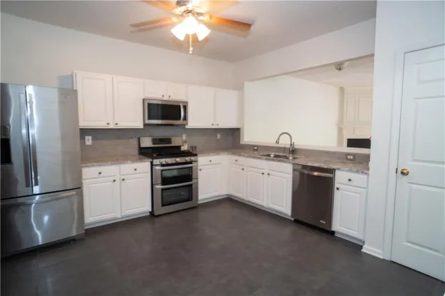a kitchen with granite countertop stainless steel appliances and white cabinets