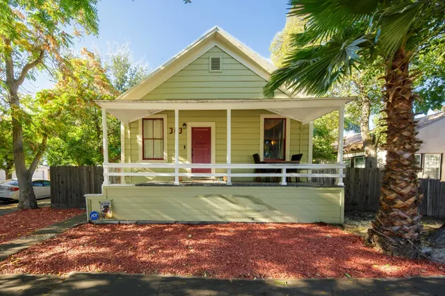 a view of a house with backyard and a tree