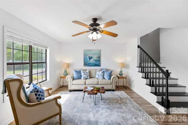 a living room with furniture chandelier and a window