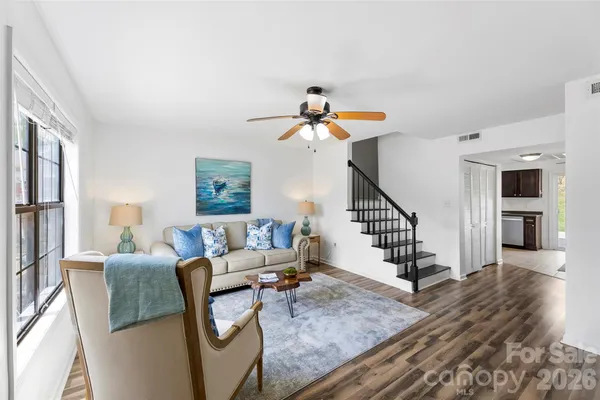 a living room with furniture and wooden floor