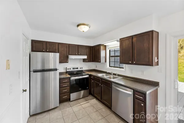a kitchen with stainless steel appliances granite countertop a stove refrigerator and microwave