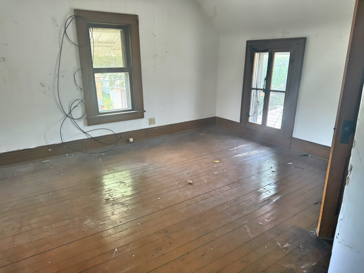 313 North 5th Street Watseka, IL 60970 - Photo 14 of 16 an empty room with wooden floor and windows