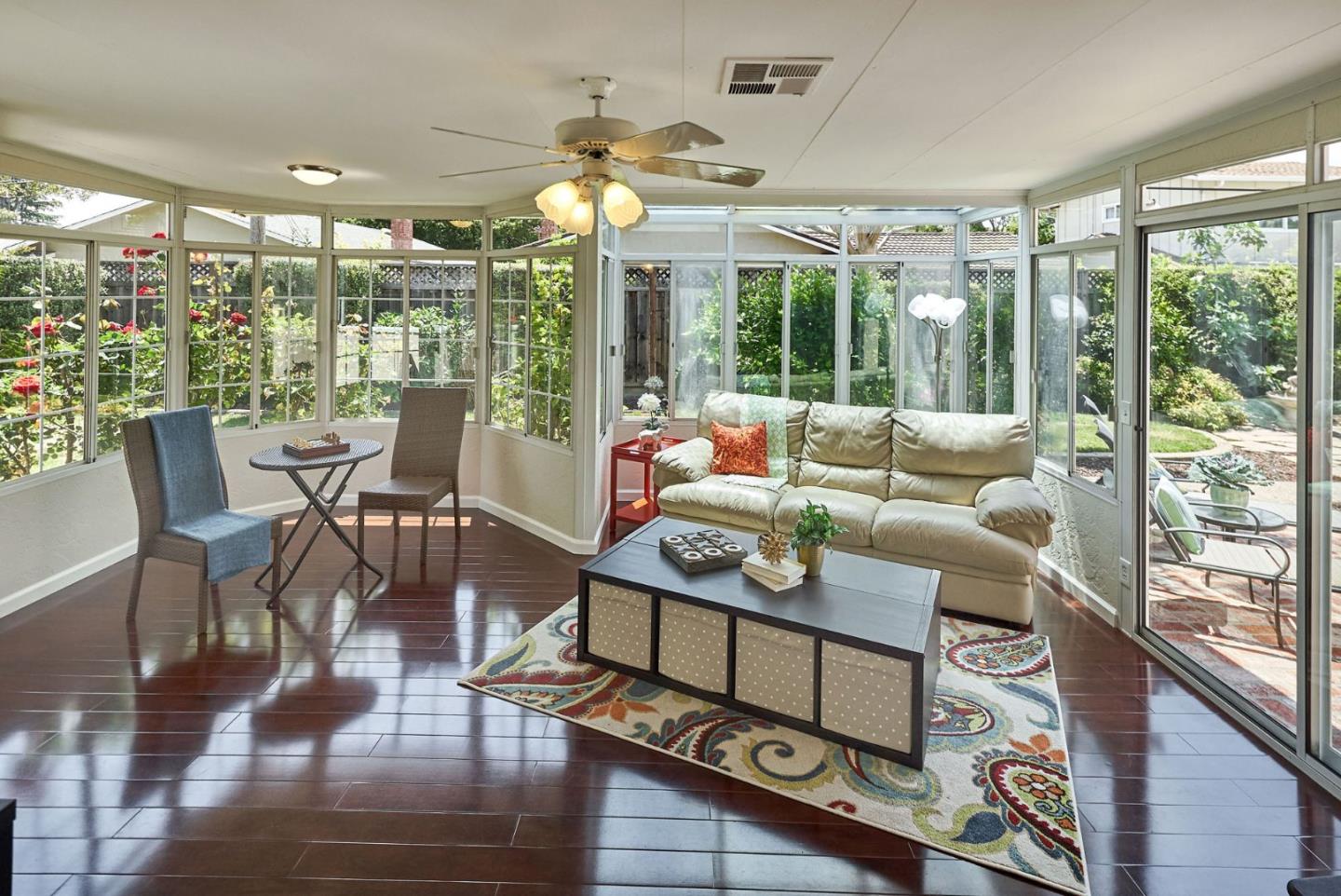 a living room with furniture large windows and wooden floor