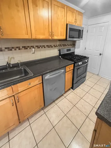 a kitchen with stainless steel appliances a stove a sink and a microwave