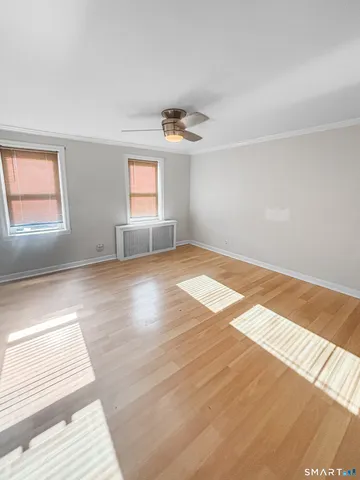 a view of empty room with window and wooden floor