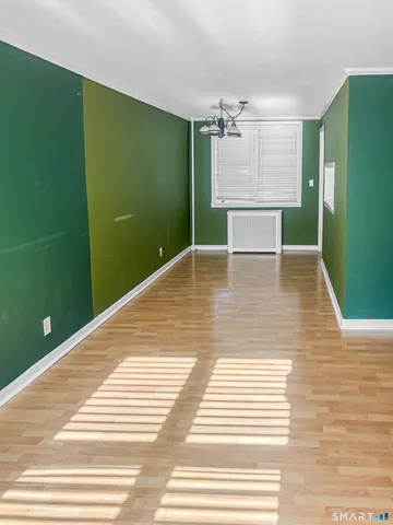 a view of a kitchen with wooden floor and a hallway