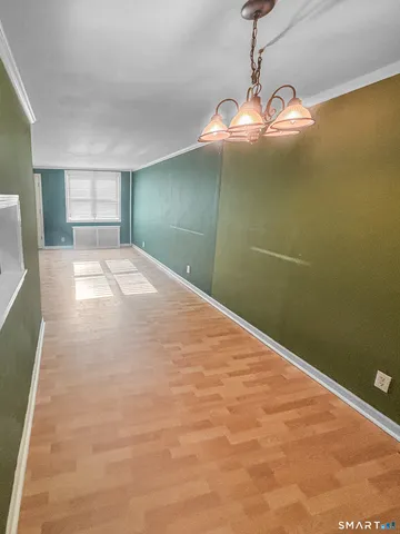 a view of empty room with window and chandelier fan