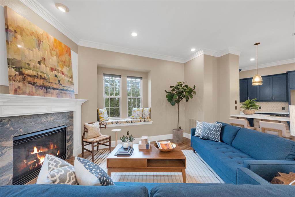 5102 Ridgedale Avenue Dallas, TX 75206 - Photo 3 of 27 Living area featuring a fireplace with a stone surround and a substantial mantel, recessed lighting, crown molding, a built-in window seat, and wood-finish flooring
