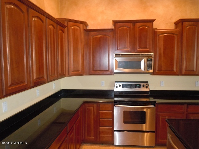 435 South Neuman Way Chandler, AZ 85225 - Photo 7 of 28 a kitchen with granite countertop wooden cabinets and stainless steel appliances
