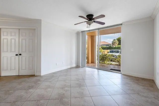 a view of an empty room and window ceiling fan