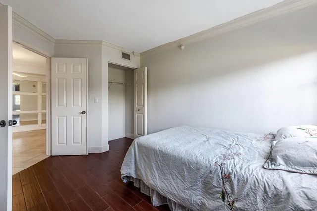a bedroom with a bed and wooden floor
